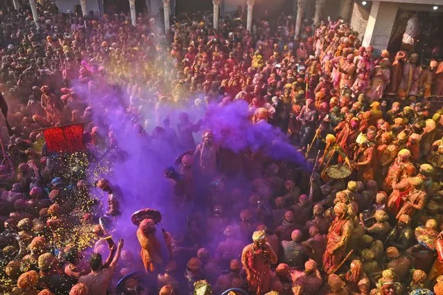 Villagers from Barsana and Nandgaon smeared with colors play Lathmar Holi at Nandagram temple in Nandgoan village, 115 kilometers (70 miles) south of New Delhi, India, Tuesday, March 19, 2024. Women from Nandgaon, the birthplace of Hindu God Krishna, beat the men from Barsana, the legendary birthplace of Radha, the consort of Krishna, with wooden sticks in response to their efforts to put color on them. The same act is then replicated in Barsana between the women of that village and the men of Nandgaon as they observe the Lathmar Holi festival, a celebration of love and friendship. (Photo by Kabir Jhangiani/AP Photo)