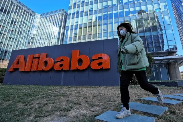 A woman wearing a face mask run past the offices of Chinese e-commerce firm Alibaba in Beijing, Monday, December 13, 2021. An employee of Chinese e-commerce giant Alibaba who was fired after she went public with a sеxual assault allegation told a local newspaper that published Saturday, Dec. 11, 2021, that she is not encouraging other victims in China to come forward because doing so “will only cause them to suffer more hurt”. (Photo by Andy Wong/AP Photo)