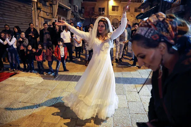 A woman dances as Arab and Jewish players compete in a backgammon championship organised by Double Yerushalmi, a group trying to build closer ties between Arabs and Jews through cultural activities, in Jerusalem February 27, 2017. (Photo by Ammar Awad/Reuters)