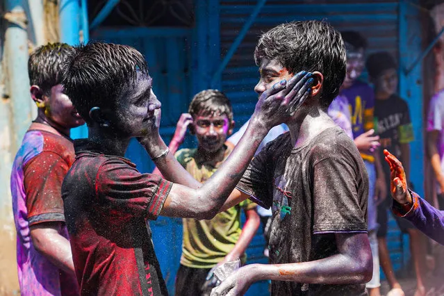 Two young people paint each other's faces with a mixture of colored powders to celebrate the Dol Purnima festival know as Holi Festival at Sakhari Bazar on March 26, 2024 in Dhaka, Bangladesh. (Photo by Nahid Hasan/Eyepix Group/Rex Features/Shutterstock)