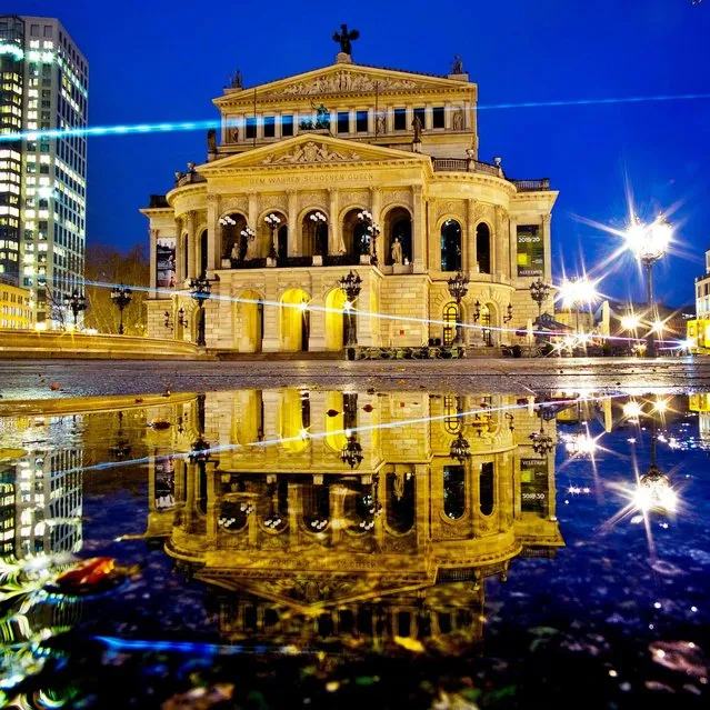 The Old Opera is reflected in a puddle in Frankfurt, Germany, early Friday, April 5, 2019. (Photo by Michael Probst/AP Photo)