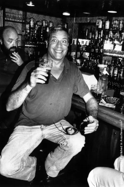 1984: Film star Oliver Reed pulls a face for the photographer  while enjoying a pint of beer in a well stocked bar