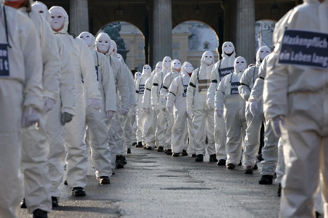 Protesters in white suits and wearing masks attend a demonstration against the coronavirus disease (COVID-19) measures and their economic consequences in Vienna, Austria, January 16, 2021. (Photo by Lisi Niesner/Reuters)
