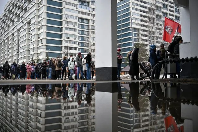 Voters queue at a polling station at noon local time in Moscow, Russia, on Sunday, March 17, 2024. The Russian opposition has called on people to head to polling stations at noon on Sunday in protest as voting takes place on the last day of a presidential election that is all but certain to extend President Vladimir Putin's rule after he clamped down on dissent. AP can't confirm that all the voters seen at the polling station at noon were taking part in the opposition protest. (Photo by AP Photo)