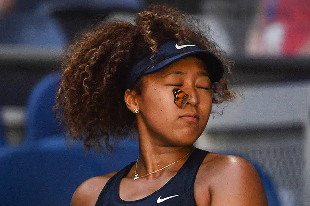 A butterfly lands on Japan's Naomi Osaka as she plays against Tunisia's Ons Jabeur during their women's singles match on day five of the Australian Open tennis tournament in Melbourne on February 12, 2021. (Photo by Paul Crock/AFP Photo)