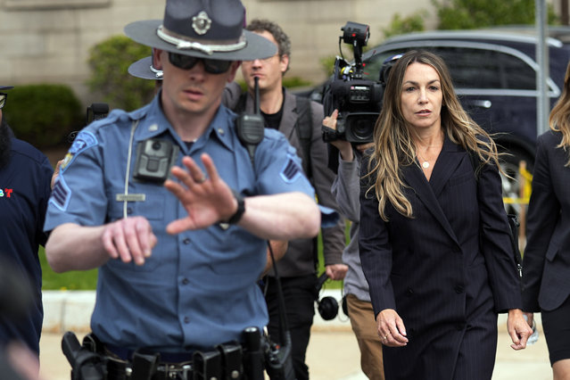 Karen Read, right, is flanked by Massachusetts State Police while leaving Norfolk Superior Court after the opening day of her trial, Monday, April 29, 2024, in Dedham, Mass. Read is charged with killing her Boston police officer boyfriend by intentionally driving her SUV into him. (Photo by Charles Krupa/AP Photo)
