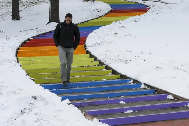 A pedestrian walks down a set of painted steps at Tufts University following a snow storm on the second day of spring in Medford, Massachusetts March 21, 2016. (Photo by Brian Snyder/Reuters)