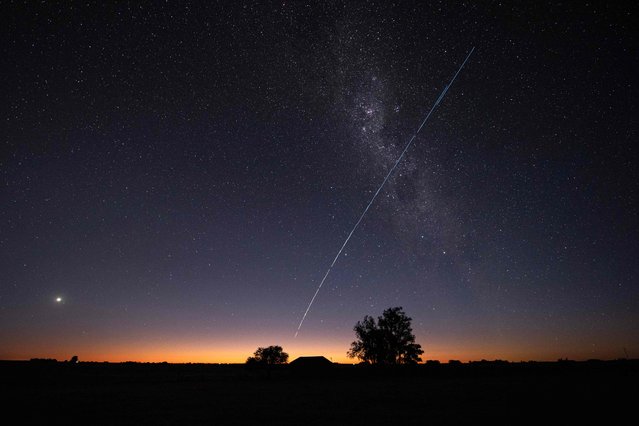 This long-exposure image shows a trail of a group of SpaceX's Starlink G6-27 satellites passing over Uruguay, with part of the Milky Way and planet Venus (L) in the frame, as seen from the countryside some 185 km north of Montevideo near Capilla del Sauce, Florida Department, at twilight early on November 12, 2023. (Photo by Mariana Suarez/AFP Photo)