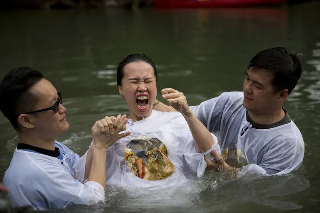 Indonesian priests baptize a Christian pilgrim in Jordan river at the Yardenit baptismal site in Israel, Friday, March 17, 2017. (Photo by Dusan Vranic/AP Photo)