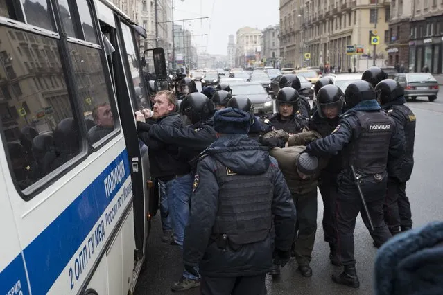 Police officers detain people in the main street in Moscow, Russia, Sunday, April 2, 2017. Russian prosecutors have moved to block calls on social networks ahead of street protests in Moscow and other Russian cities following a wave of rallies. (Photo by Pavel Golovkin/AP Photo)