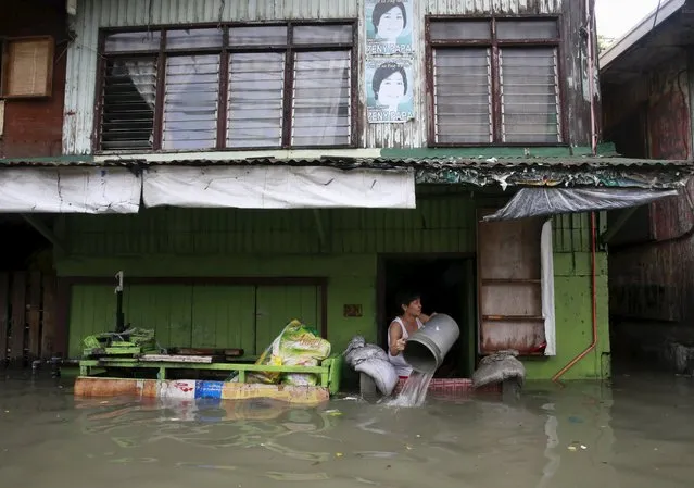 A woman clears flood water that entered her home, caused by typhoon Linfa, locally named Egay, at Longos town in Malabon city, north of Manila July 6, 2015. (Photo by Romeo Ranoco/Reuters)