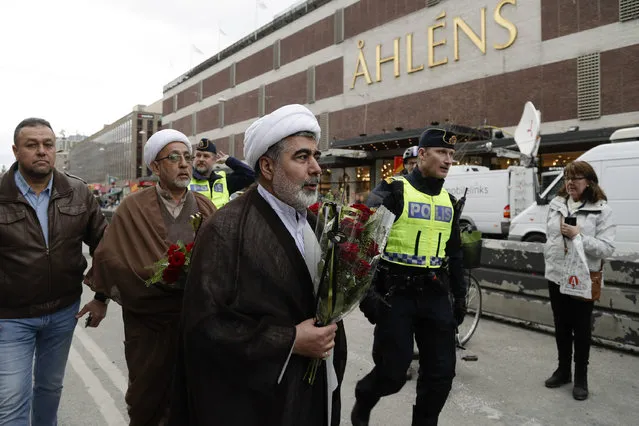 Muslim clerics arrive to lay down flowers near the department store Ahlens following a suspected terror attack in central Stockholm, Sweden, Saturday, April 8, 2017. Swedish prosecutor Hans Ihrman said a person has been formally identified as a suspect “of terrorist offences by murder” after a hijacked truck was driven into a crowd of pedestrians and crashed into a department store on Friday. (Photo by Markus Schreiber/AP Photo)
