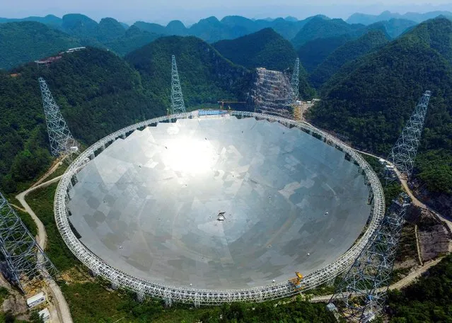 A 500-metre (1,640-ft.) aperture spherical telescope (FAST) is seen at the final stage of construction, among the mountains in Pingtang county, Guizhou province, China, May 7, 2016. (Photo by Reuters/Stringer)