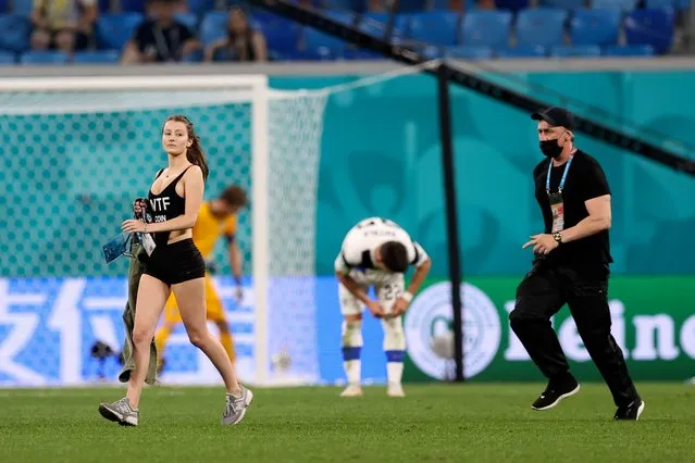 Stadium security stop a pitch invader during the UEFA EURO 2020 Group B football match between Finland and Belgium at Saint Petersburg Stadium in Saint Petersburg, Russia, on June 21, 2021. (Photo by Kirill Kudryavtsev/Pool via AFP Photo)