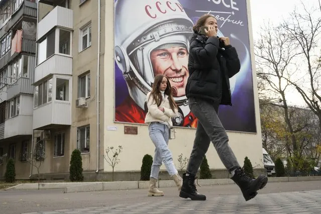 People walk past a billboard depicting the first cosmonaut Yuri Gagarin in Tiraspol, the capital of the breakaway region of Transnistria, a disputed territory unrecognized by the international community, in Moldova, November 1, 2021. For some European countries watching Russia's bloody invasion of Ukraine, there are fears that they could be next. Western officials say the most vulnerable could be those who are not members of the NATO military alliance or the European Union, and thus alone and unprotected – including Ukraine’s neighbor Moldova and Russia's neighbor Georgia, both of them formerly part of the Soviet Union – along with the Balkan states of Bosnia and Kosovo. (Photo by Dmitri Lovetsky/AP Photo/File)