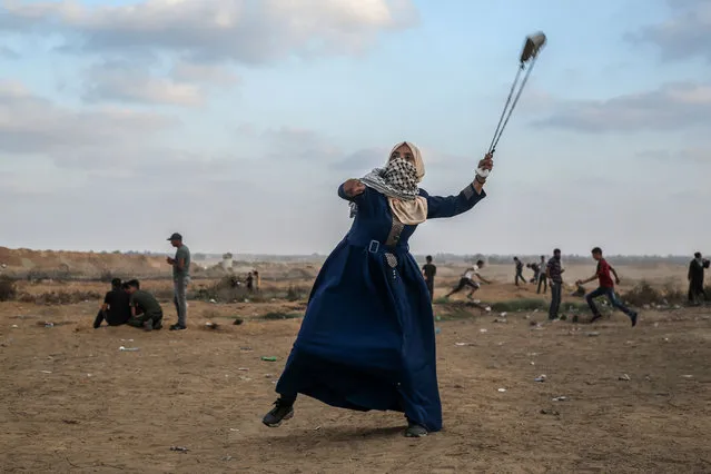 A Palestinian protester uses a slingshot to hurl stones during clashes with Israeli forces across the barbed-wire fence following a demonstration along the border with Israel east of Khan Yunis in the southern Gaza strip on September 13, 2019. (Photo by Said Khatib/AFP Photo)