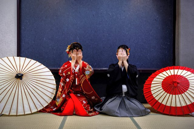 A transgender couple, consisting of a queer transgender man (L), 33, and a pansеxual 32-year-old woman (R), cover their faces at the request of a Reuters photographer as they pose for their wedding photos at the wedding photography business Onestyle's studio, in Tokyo, Japan on August 23, 2023. (Photo by Kim Kyung-Hoon/Reuters)