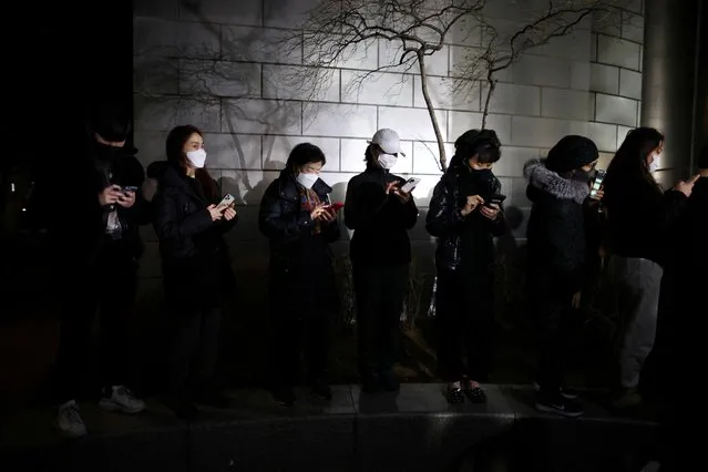 Supporters for South Korea's President-elect Yoon Suk-yeol watch a live report broadcasting the results of the presidential election in Seoul, South Korea, March 10, 2022. (Photo by Kim Hong-Ji/Reuters)