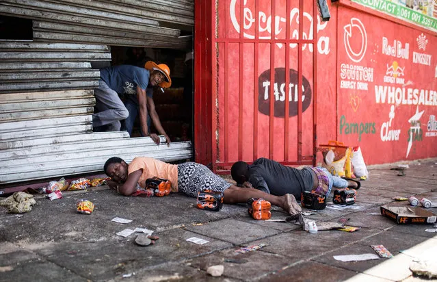 South African looters lay on the ground after South African Police officers intervened during a riot in the Johannesburg suburb of Turffontein on September 2, 2019 as angry protesters loot alleged foreign-owned shops in a new wave of violence targeting foreign nationals. (Photo by Guillem Sartorio/AFP Photo)