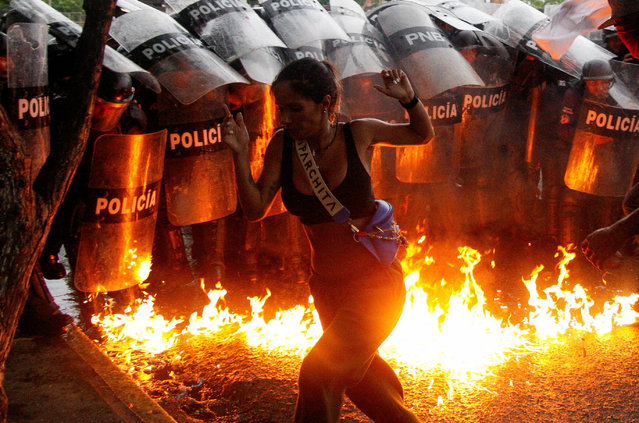 A demonstrator reacts when Molotov cocktails hit the ground in front of security forces during protests against election results after Venezuela's President Nicolas Maduro and his opposition rival Edmundo Gonzalez claimed victory in Sunday's presidential election, in Puerto La Cruz, Venezuela on July 29, 2024. (Photo by Samir Aponte/Reuters)