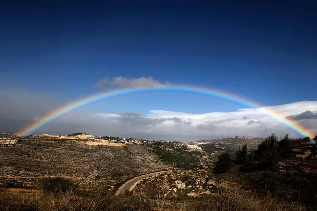 This picture taken on December 20, 2021 shows a view of a rainbow in the sky above the Israeli settlement of Eli, south of Nablus in the occupied West Bank. (Photo by Jaafar Ashtiyeh/AFP Photo)