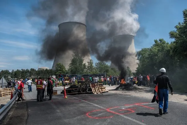 Trade unionists block the entrance of the Nogent Nuclear Power Plant with burning objects to protest against the French labor reform law, in Nogent sur Seine, France, 26 May 2016. A strike hits oil refineries, fuel depots, petrol stations and nuclear plants across France. (Photo by Christophe Petit Tesson/EPA)
