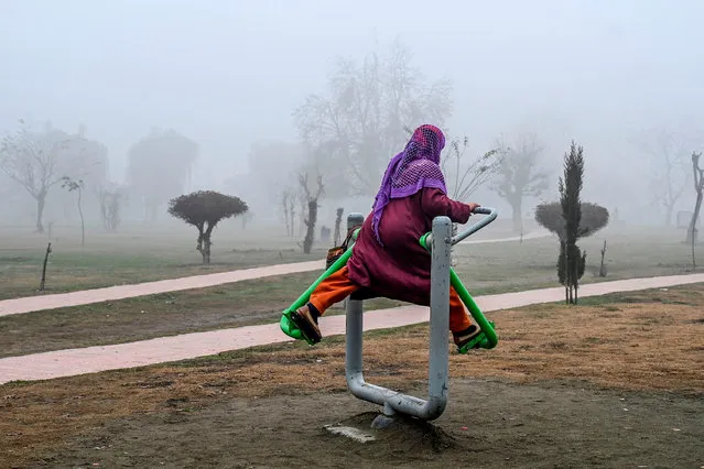 A woman exercises inside a park amid fog in Srinagar on December 10, 2019. (Photo by Tauseef Mustafa/AFP Photo)