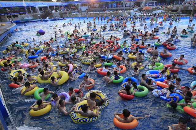 Chinese holidaymakers crowd a swimming pool at a water park in Nanchang city, east China's Jiangxi province, 16 July 2017. (Photo by Imaginechina/Rex Features/Shutterstock)