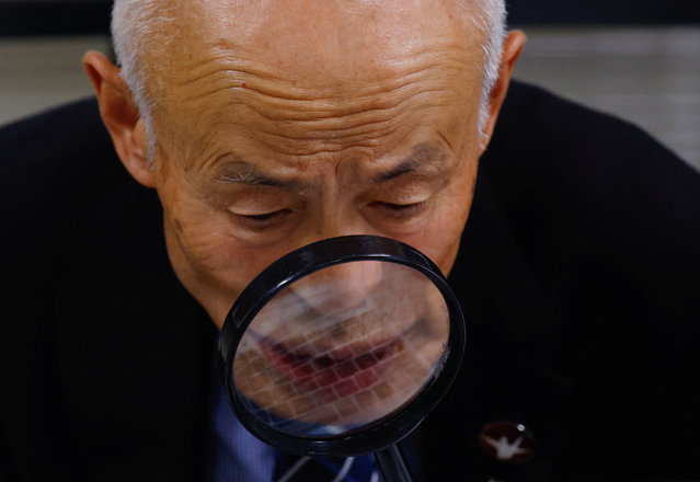 Japan Confederation of A- and H-Bomb Sufferers Organizations (Nihon Hidankyo) co-chair Toshiyuki Mimaki, who survived the 1945 atomic bombing of Hiroshima, uses a magnifier to see the monitor on a laptop while attending a press conference via an online video call in Hiroshima, western Japan, on October 12, 2024. (Photo by Kim Kyung-Hoon/Reuters)