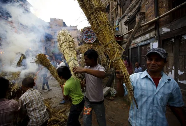 People carry an effigy of the demon Ghantakarna, while another effigy of the demon is burnt to symbolize the destruction of evil, during the Ghantakarna festival in the ancient city of Bhaktapur, Nepal August 12, 2015. According to local folklore, the demon is believed to “steal” children and women from their homes and localities. (Photo by Navesh Chitrakar/Reuters)