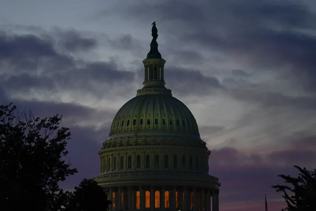 The sun sets behind the U.S. Capitol Thursday, June 9, 2022, in Washington, as the House select committee holds its first public hearing in its investigation of the Jan. 6 attack on the U.S. Capitol.. (Photo by Julio Cortez/AP Photo)