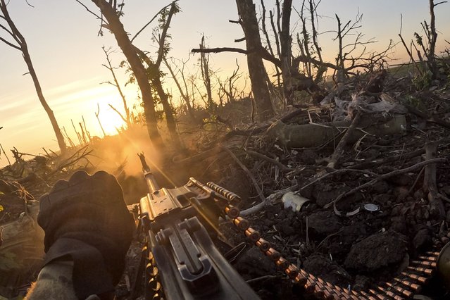 In this image taken from a video released by the 3rd Assault Brigade, a Ukrainian servicemen fires machine gun towards Russian positions near Andriivka, Donetsk region, Ukraine, August 27, 2023. Ukrainian brigade's two-month battle to fight its way through a charred forest shows the challenges of the country's counteroffensive in the east and south. (Photo by AP Photo/Stringer)