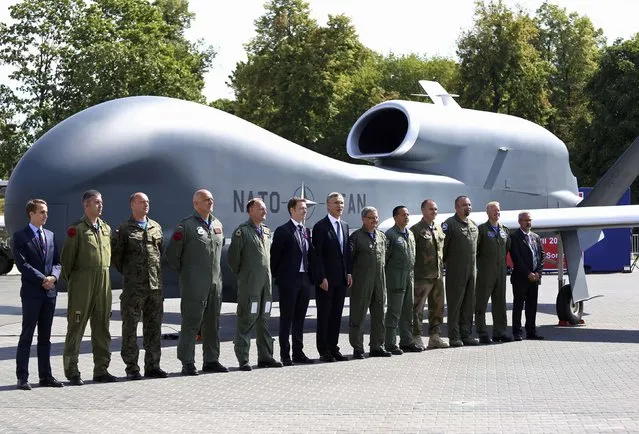 NATO Secretary-General Jens Stoltenberg (C) poses with officials and military personnel in front of a NATO unmanned drone outside PGE National Stadium, the venue of the NATO Summit, in Warsaw, Poland, July 8, 2016. (Photo by Adam Stepien/Reuters/Agencja Gazeta)