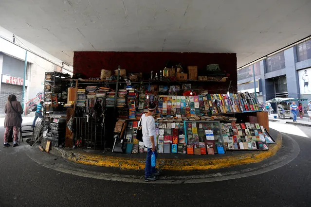 A woman stands as she looks at a book stall trade in Caracas, Venezuela, July 3, 2016. (Photo by Carlos Jasso/Reuters)
