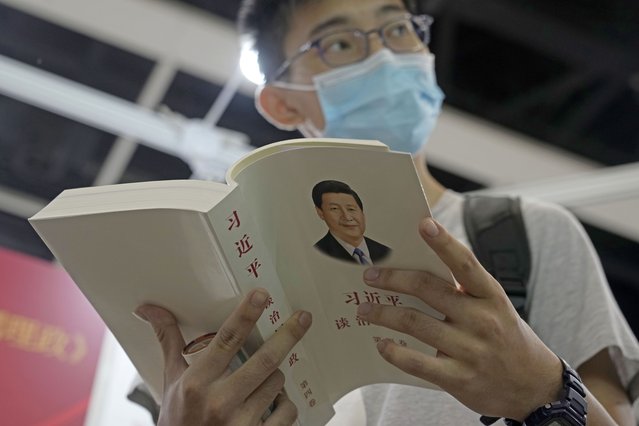 A man reads the books “Xi Jinping: The Governance of China” at a booth during the annual book fair in Hong Kong, Wednesday, July 20, 2022. The Hong Kong Book Fair will be held on July 20-26. (Photo by Kin Cheung/AP Photo)