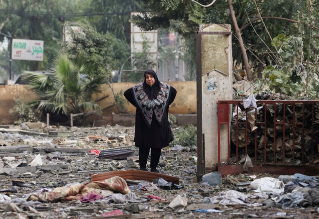 A woman stands on the rubble of damaged buildings in Beirut's southern suburbs, after a ceasefire between Israel and Hezbollah took effect, in Lebanon on November 27, 2024. (Photo by Mohamed Azakir/Reuters)
