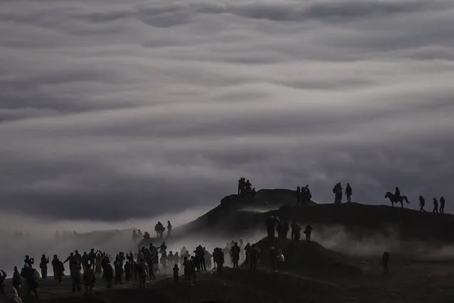 Tenggerese worshippers trek across the “Sea of Sand” to give their offerings to Mount Bromo during the Yadnya Kasada Festival at crater of Mount Bromo on August 12, 2014 in Probolinggo, East Java, Indonesia. (Photo by Ulet Ifansasti/Getty Images)
