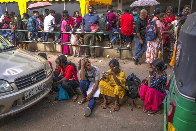 People wait in queue to get their passports outside Department of Immigration & Emigration in Colombo, Sri Lanka, Monday, July 18, 2022. (Photo by Rafiq Maqbool/AP Photo)