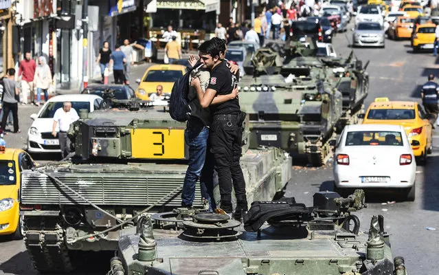 Turkish police officer (R) embrace a man on a tank after the military position was taken over at the Anatolian side at Uskudar in Istanbul on July 16, 2016. President Recep Tayyip Erdogan urged Turks to remain on the streets on July 16, 2016, as his forces regained control after a spectacular coup bid by discontented soldiers that claimed more than 250 lives. Describing the attempted coup as a “black stain” on Turkey's democracy, Yildirim said that 161 people had been killed in the night of violence and 1,440 wounded. (Photo by Bulent Kilic/AFP Photo)