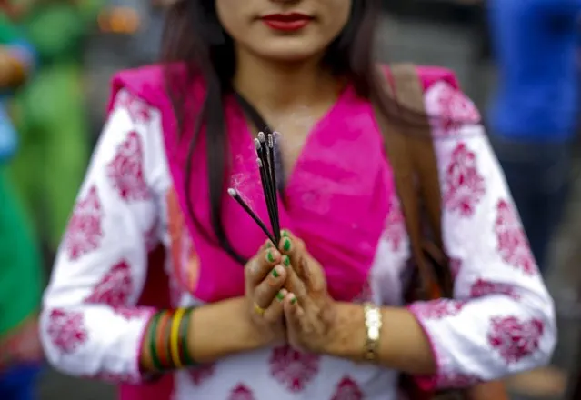 Nepalese Hindu women pray to worship Lord Shiva during the first day of the Sarwan Brata festival, the month of fasting, at the premises of Pashupati Temple in Kathmandu, Nepal, 18 July 2016. Thousands of married and single Nepalese Hindu women will gather in temples for each Monday of the Sawan month (spanning from 16 July to 16 August) to pray for a long and prosperous life of their husbands or for a chance to find a good one. (Photo by Narendra Shrestha/EPA)