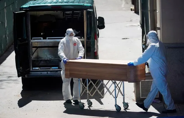Mortuary workers push a coffin of a person who died at a nursing home during the coronavirus disease (COVID-19) outbreak in Leganes Madrid, near Madrid, Spain, April 2, 2020. (Photo by Juan Medina/Reuters)