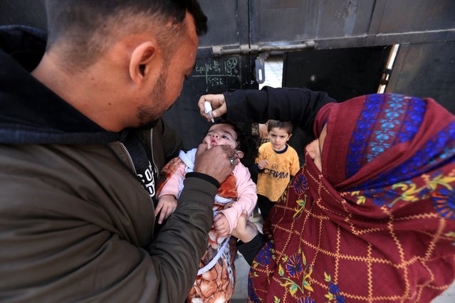 A health worker administers polio vaccine to a child during a door-to-door vaccination campaign in Peshawar, KPK province, Pakistan, 17 December 2024. At least one health worker and two police officers were killed in attacks targeting vaccination teams in Pakistan, as the country began a week-long nationwide anti-polio campaign on 16 December aiming to vaccinate approximately 44 million children under five after 63 poliovirus cases were reported this year. (Photo by Bilawal Arbab/EPA/EFE)