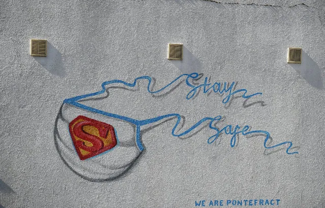 Graffiti depicting the badge of the fictional super heros Superman and Superwoman, and forming the logo of a personal protective equipment (PPE) face mask with the words “Stay Safe”, is pictured on a wall in Pontefract, northern England on April 14, 2020, as life in Britain continues during the nationwide lockdown to combat the novel coronavirus pandemic. The British government warned Monday it would not be lifting a nationwide lockdown anytime soon as the country remains in the grip of a coronavirus outbreak that has claimed more than 11,000 lives. (Photo by Oli Scarff/AFP Photo)