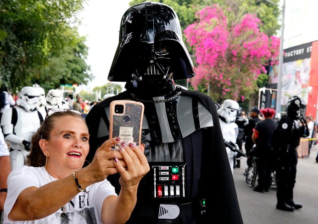 A woman poses for a selfie as fans of the Star Wars saga fancy dressed as the characters take part in the so-called “Training Day” parade, at Vallarta Avenue in Guadalajara, state of Jalisco, Mexico, on October 7, 2023. (Photo by Ulises Ruiz/AFP Photo)