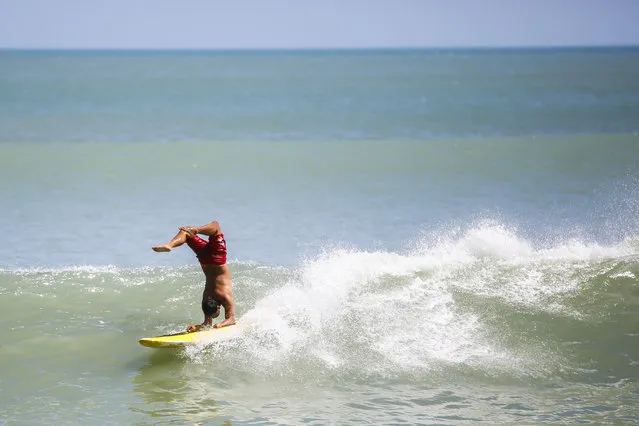 Tourists surf at a beach in Kuta, Bali, Indonesia, August 13, 2014. In the first half of 2014 the number of tourists visiting Indonesia increased by about 9.6 percent to 4.55 million from 4.15 million visitor in the same period last year. Indonesia may achieve about 14 percent growth in foreign tourist arrivals in 2014, according to the World Travel & Tourism Council (WTTC). (Photo by Made Nagi/EPA)