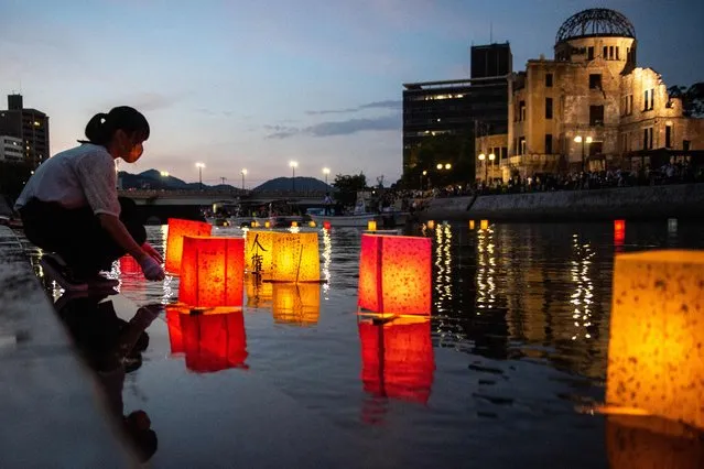 People release paper lanterns on the Motoyasu River beside the Hiroshima Prefectural Industrial Promotion Hall, commonly known as the atomic bomb dome, to mark the 77th anniversary of the world's first atomic bomb attack in Hiroshima on August 6, 2022. (Photo by Philip Fong/AFP Photo)