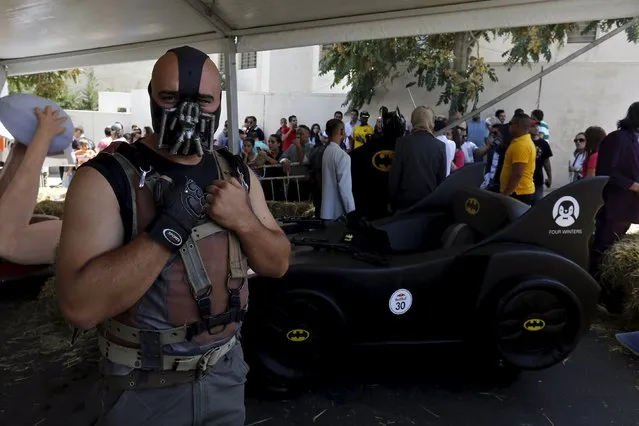 A competitor wearing a mask poses with his homemade vehicle without an engine before the start of the Red Bull Soapbox Race in Amman, Jordan September 4, 2015. (Photo by Muhammad Hamed/Reuters)
