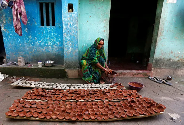 A woman colours earthen lamps which are used to decorate temples and homes during the Hindu festival of Diwali, in Kolkata, India October 12, 2017. (Photo by Rupak De Chowdhuri/Reuters)
