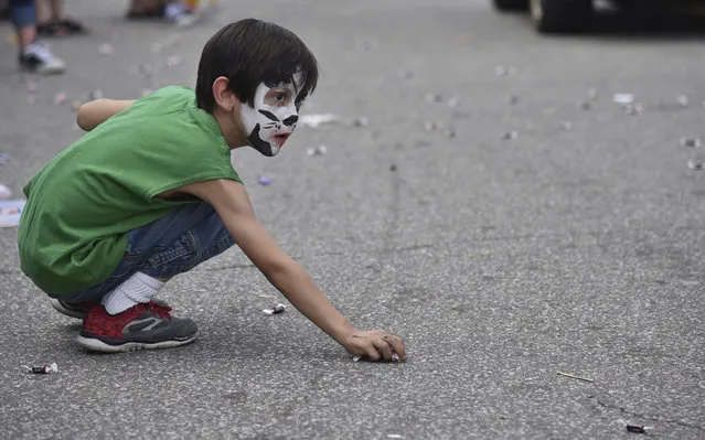 Andrew Little, 5, with his face painted like a puppy picks up candy while watching for more to be tossed his way during the Old Fashion Days parade Saturday, October 8, 2017 in Greenup, Ky. (Photo by Kevin Goldy/The Daily Independent via AP Photo)