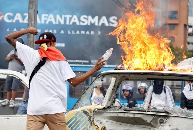 A protester pours gasoline over a car wreck during a rally to demand a referendum to remove Venezuela's President Nicolas Maduro in Caracas, Venezuela, September 1, 2016. (Photo by Carlos Garcia Rawlins/Reuters)